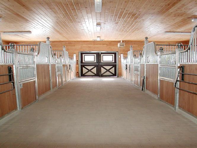 Aisle view of multiple Tuscany horse stalls